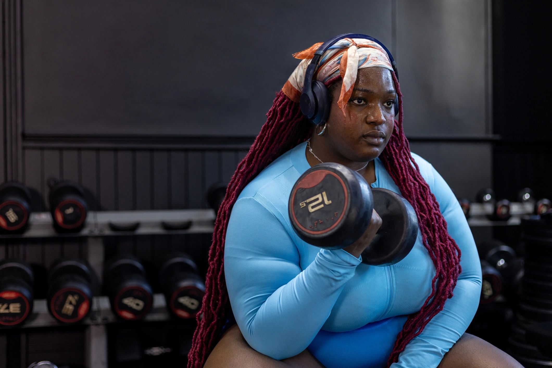 Woman strength training with dumbbell on a bench